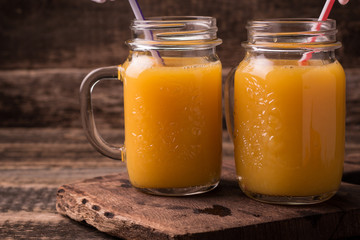 Citrus juice and fruits on wooden background.