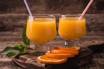 Citrus juice and fruits on wooden background.