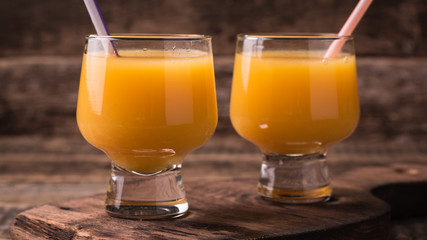 Citrus juice and fruits on wooden background.