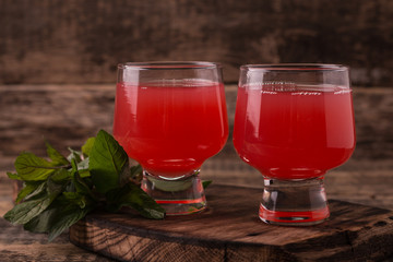 Citrus juice and fruits on wooden background.