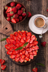 Tart with strawberries and whipped cream on wooden vintage table