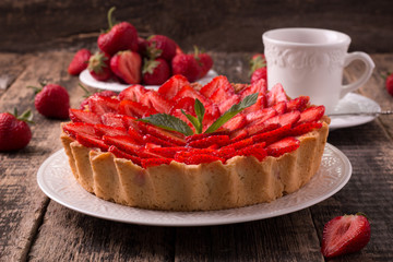 Tart with strawberries and whipped cream on wooden vintage table