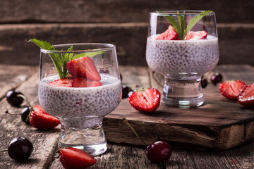 chia seed pudding with strawberries and min on wooden vintage background