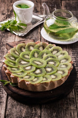 Tart with kiwi and whipped cream on wooden vintage table