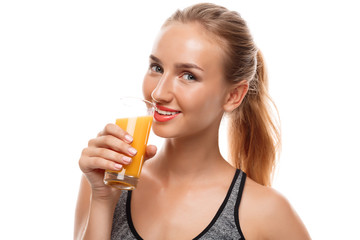 Beautiful sportive girl holding glass with juice over white background.