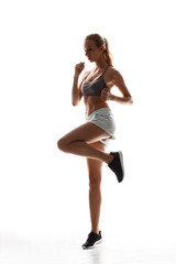 Beautiful sportive girl training over white background.