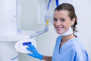 Dental assistant adjusting x-ray equipment