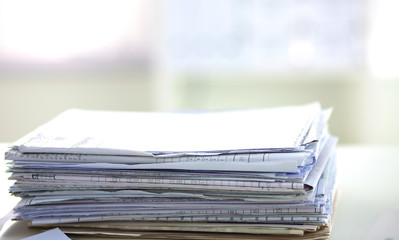 stack of papers on the desk with computer
