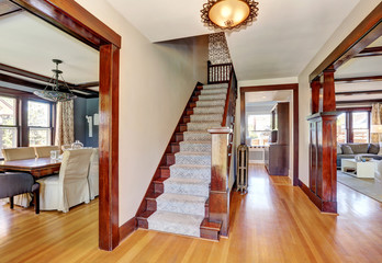 Interior of hallway with staircase and hardwood floor.