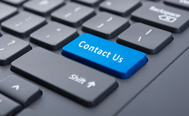 Blue contact us button on black keyboard concept