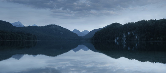 Alpsee, panoramic view of a calm lake after sunset