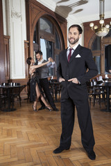 Confident Man Standing While Dancers Performing Tango