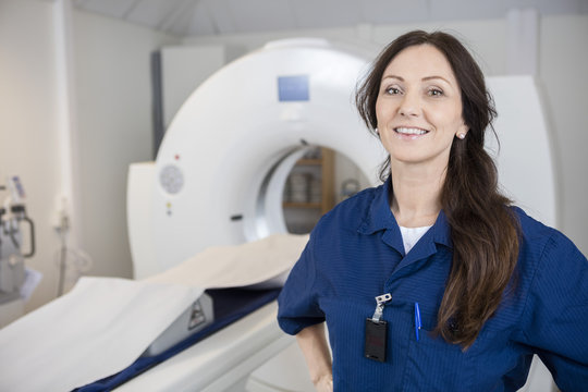 Female Professional Smiling Against MRI Machine
