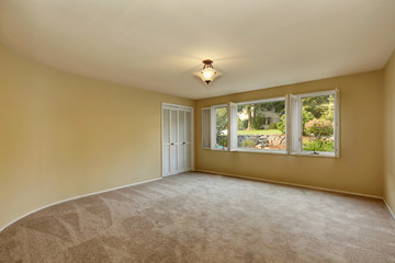 Empty room in beige and yellow colors with open window