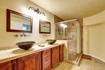 Bathroom with beige tile trim and glass shower.