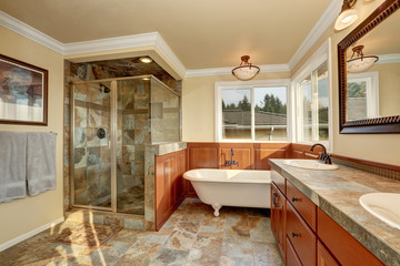 Bathroom with natural stone tile and beige walls.