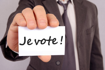 Homme tenant une carte avec &eacute;crit dessus je vote
