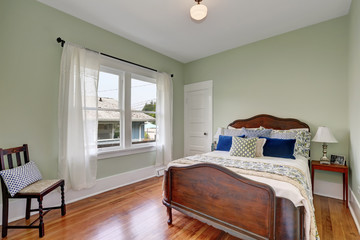 Simply furnished bedroom interior with olive green walls