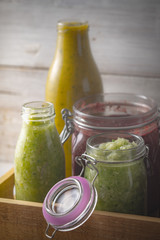 Jars with different smoothies  in the wooden box vertical