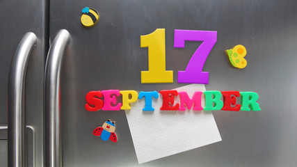 September 17 calendar date made with plastic magnetic letters holding a note of graph paper on door refrigerator