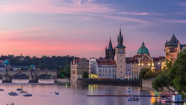 View of the city Prague in Czech Republic with colorful paddle boats day to night timelapse on the Vltava river with beautiful sky