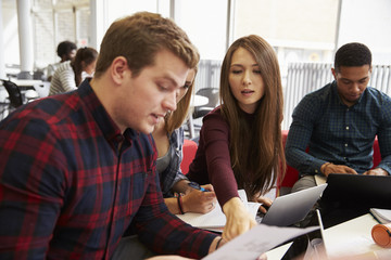 Group Of Students In Library Collaborating On Project