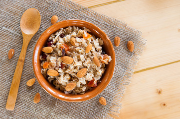 Serving muesli scattering of nuts on wooden table
