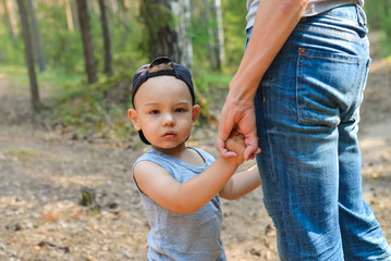Fototapeta premium Little boy close-up. Holding the hand of parents