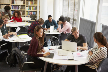 Busy University Library With Students And Tutor