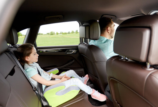 family with child in safety seat driving car