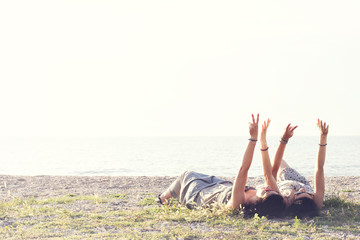  women lying in the meadow raise their arms