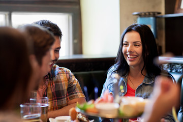happy friends with beer eating at bar or pub