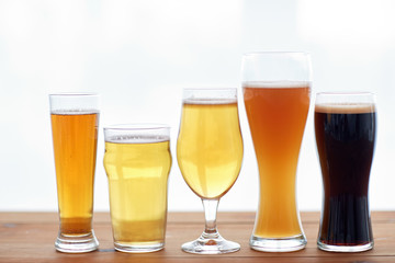 close up of different beers in glasses on table