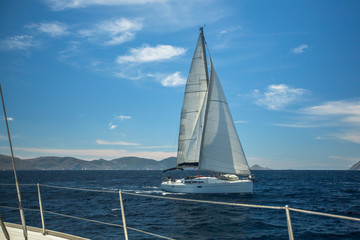 Obraz premium Sailing boats on the waves of the Aegean sea. Yachting in Greece. Luxury Yachts.