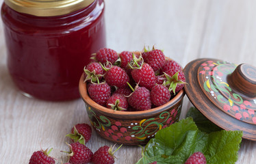 Fresh raspberries and jam .Selective focus. On wooden background.
