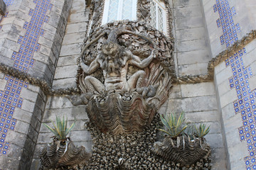Stone statue at the castle in Portugal, creepy demonic statue at the wall 