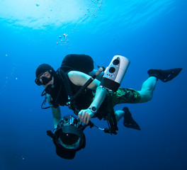 Underwater Photographer scuba diving with camera in sea