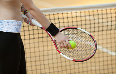 tennis racket with ball on clay court