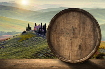 Red wine with barrel on vineyard in green Tuscany, Italy
