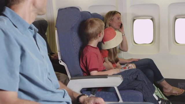 Family using cellphone on plane