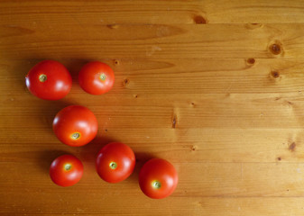 Red tomatoes and cherry at wooden table. Vegetable background.