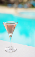 Cocktail on white table in front of swimming pool