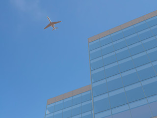 Fototapeta na wymiar Airplane over office building