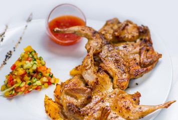 roasted quail on a baked potato with sauce