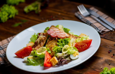 plate with salad served on a wooden table