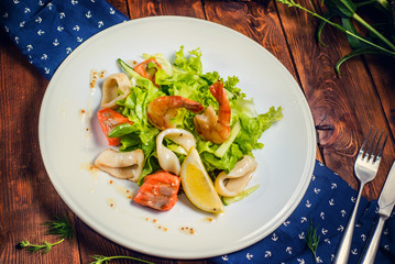plate with salad served on a wooden table