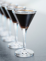 Cocktails glasses standing in a row closeup