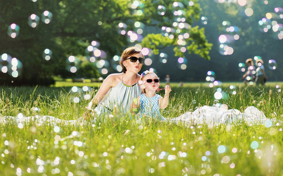 Mother and daughter family time, blowing soap-bubbles