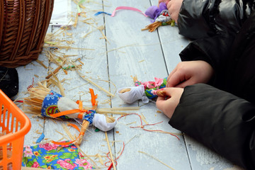 Children make up a straw Figure of Maslenitsa on the table on th