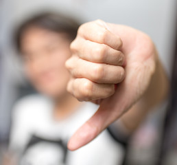 Girl showing thumbs down hand